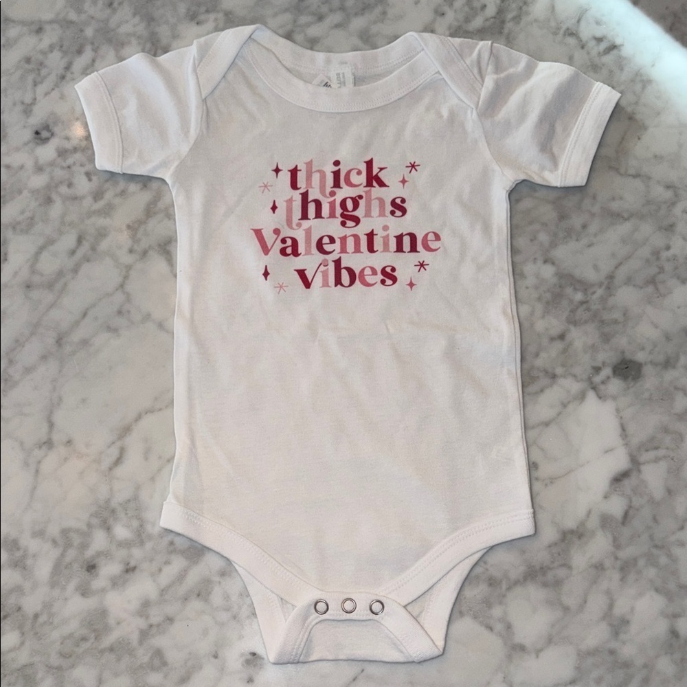 NWOT Bella Canvas White Baby Onesie with Valentine’s Pink Print 12/18M